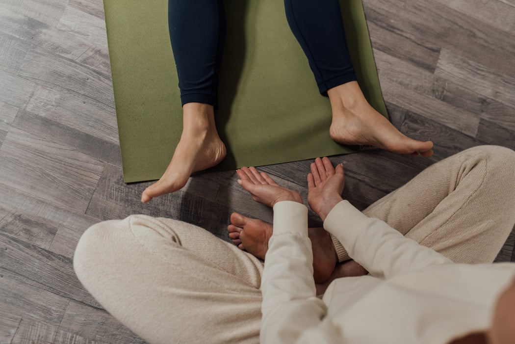 Person on Black Pants Lying on Green Yoga Mat